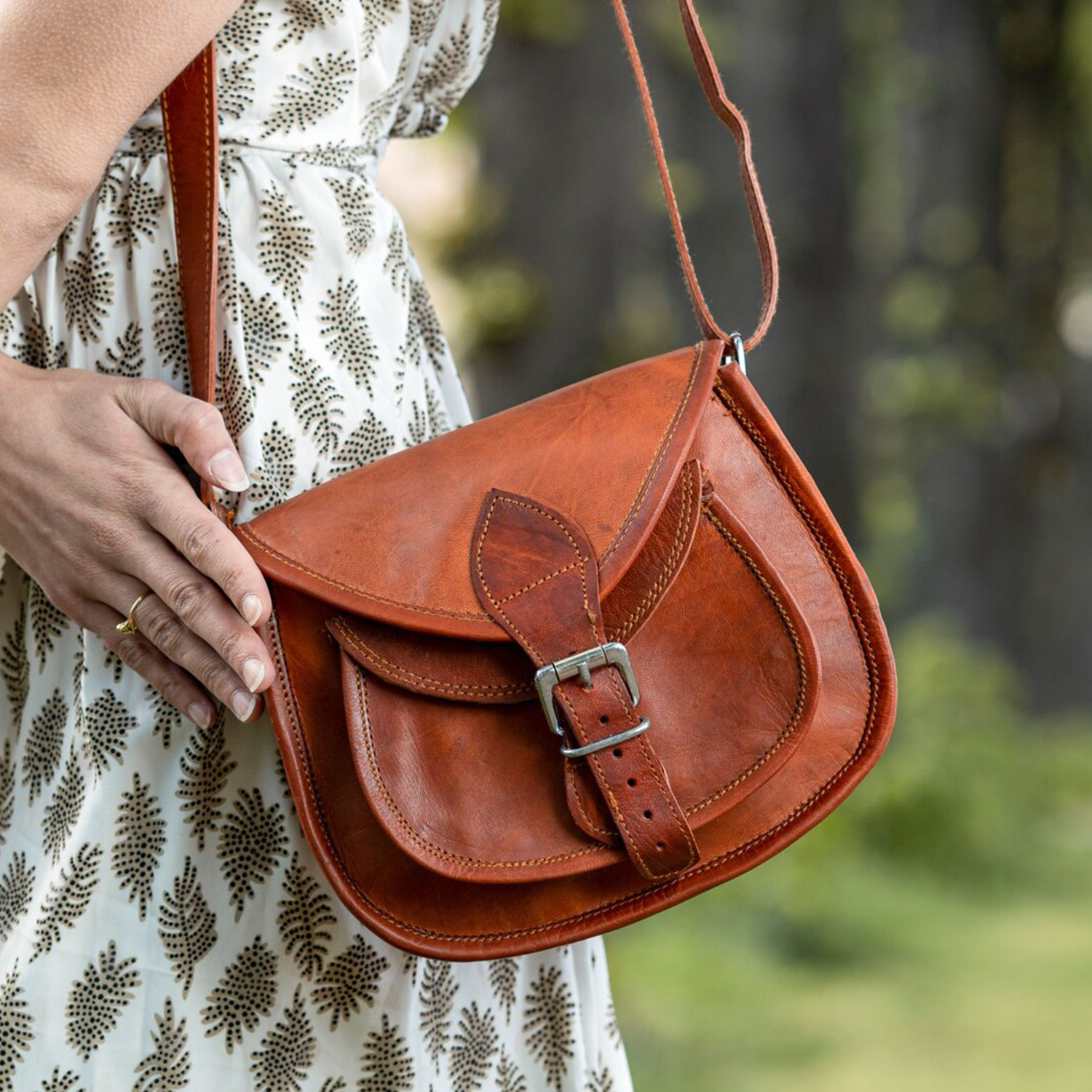 Warm Vintage Tan Aged Grain Curved Saddle Satchel With Dual Overlap Flaps, Leaf Shaped Buckle Tab Fastener And Triple Segmented Inner Storage Zones