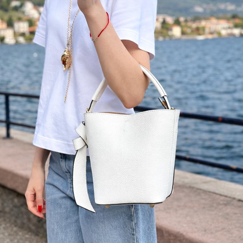 Crisp Off-White Pebbled Grain Compact Tapered Bucket Carry With Fixed Curved Top Loop, Decorative Knotted Shoulder Strap And Protective Base Foot Hardware