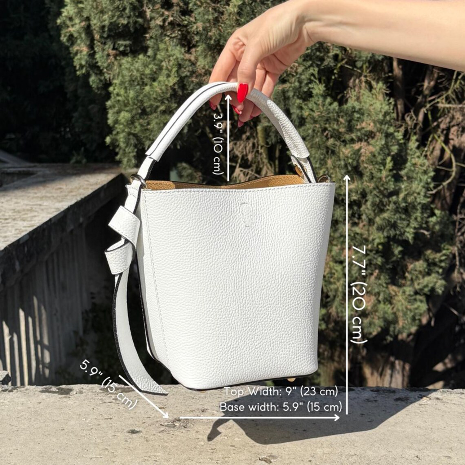Crisp Off-White Pebbled Grain Compact Tapered Bucket Carry With Fixed Curved Top Loop, Decorative Knotted Shoulder Strap And Protective Base Foot Hardware