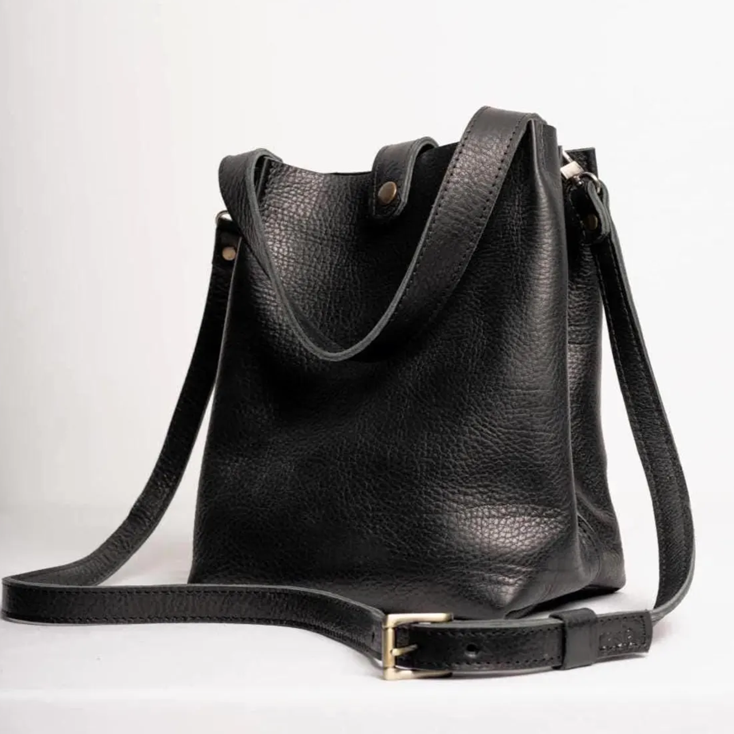 Deep Black Natural Grain Vertical Compact Bucket Carry With Fixed Short Top Loop, Buckle Adjustable Shoulder Strap And Internal Full-Length Zip Divider Compartment