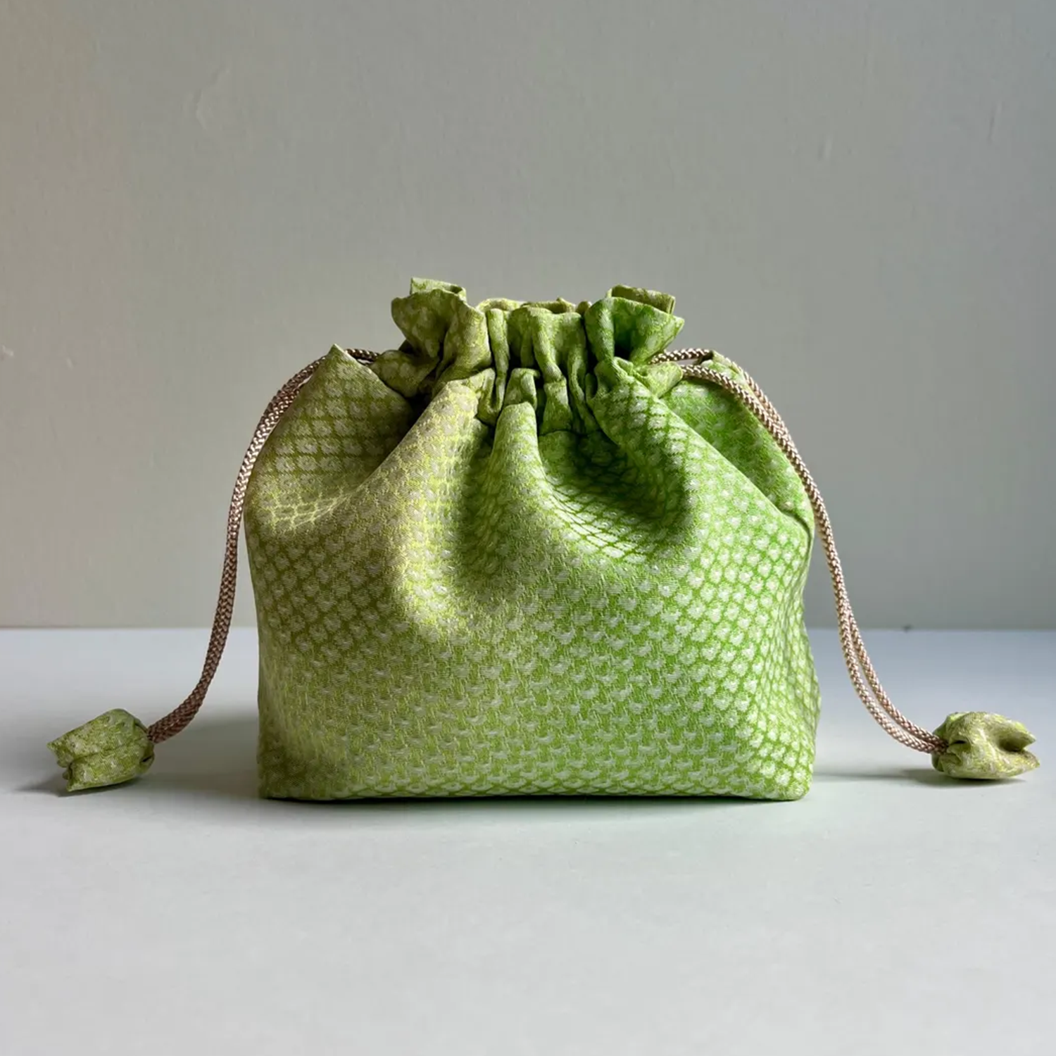 Gradient Light Green Textured Woven Drawstring Bucket Pouch With Ruffled Gathered Top, Fabric Wrapped Cord Toggles And Flat Collapsible Soft Silhouette
